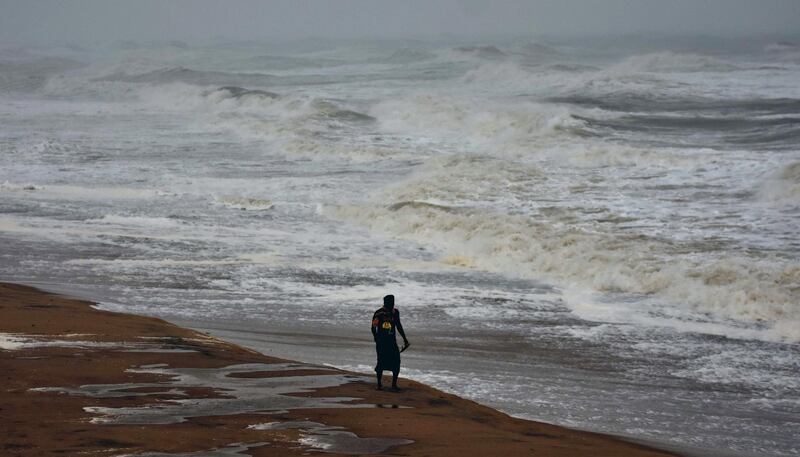 A local walks along a beach next to heavy waves brought by Cyclone Titli. AFP