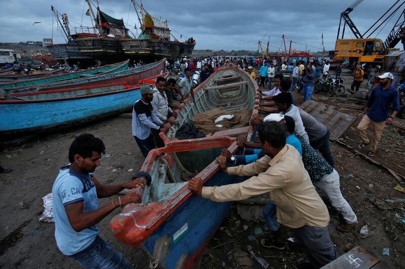 Fishermen move a fishing boat to a safer place along the shore ahead of the expected landfall of Cyclone Vayu at Veraval, India. Reuters