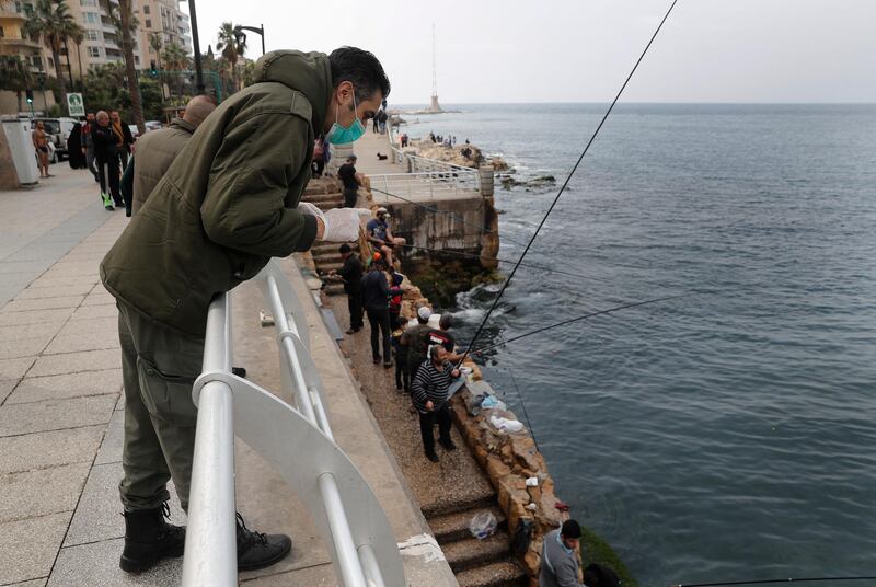 A municipal policeman, orders fishermen to leave the corniche, or waterfront promenade, along the Mediterranean Sea in Beirut. AP Photo
