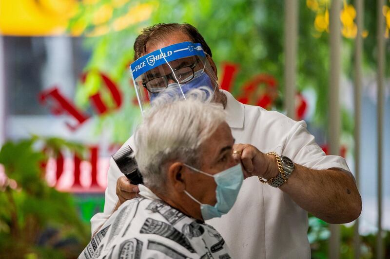 Joaquim Correia of College Barber Shop dresses a customer's hair as the provincial phase 2 of reopening from the coronavirus restrictions begins in Toronto, Ontario, Canada. Reuters