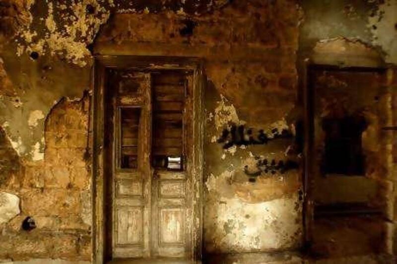 A picture shows graffiti reading in Arabic "I miss you my love" on a bullet-riddled wall inside a war-ravaged building at Sodeco Square in the Lebanese capital Beirut on April 7, 2010. With sandbags, sniper slits and pockmarked facade, the building has long been a reminder of the country's 1975-1990 civil war. As Lebanon prepares to mark the 35th anniversary of its outbreak, the building is slated to become a museum dedicated to the horrors of that war. AFP PHOTO/JOSEPH EID