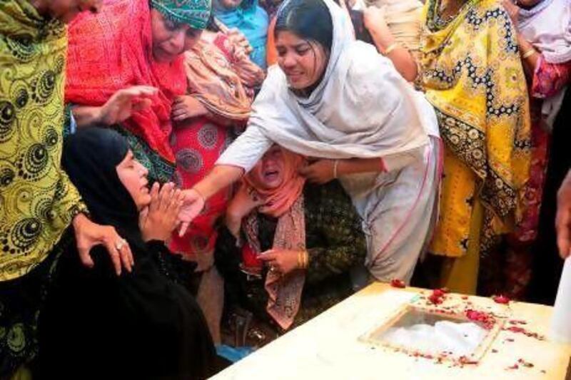 Relatives mourn next to the coffin of a passenger killed in the Bhoja Air accident, during a funeral in Karachi today.