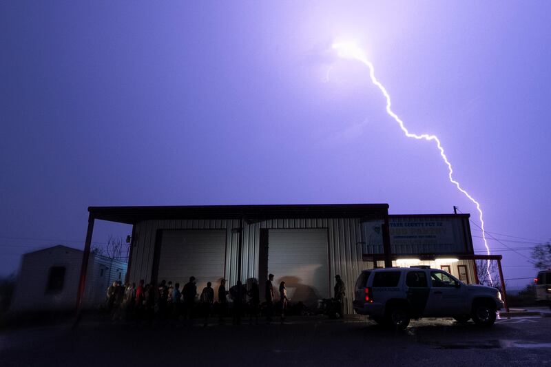 A lightning bolt lights up the sky during a storm as migrants wait to be processed by immigration officials, after they crossed the border into Texas from Mexico.  AP 