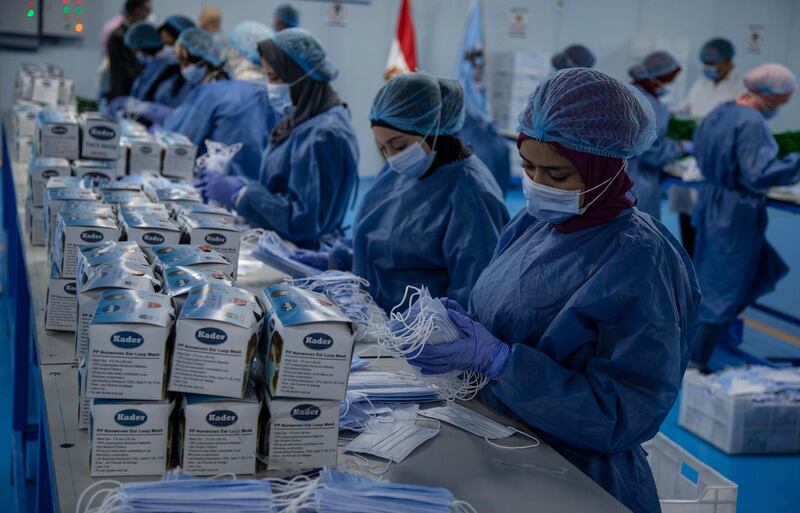 Workers at a factory produce surgical masks in Cairo, Egypt. EPA
