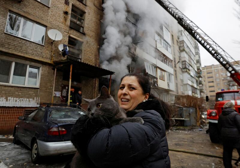 A woman with her cat, which was saved from an apartment building damaged by recent shelling in Donetsk. Reuters