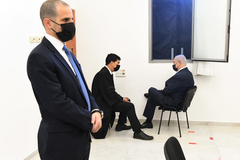 Israeli Prime Minister Benjamin Netanyahu speaks to a member of his legal team before the start of a hearing in his corruption trial at Jerusalem's District Court.  Reuters