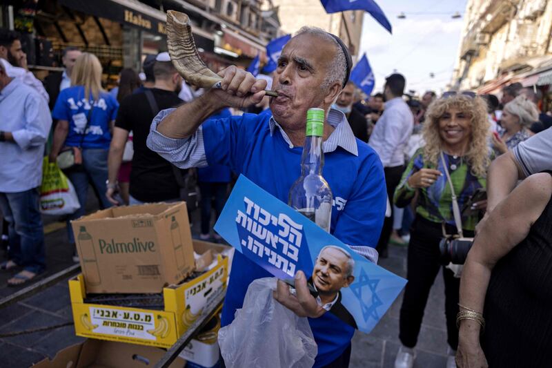 In Jerusalem, a Netanyahu supporter blows a shofar, made of a ram's horn. AFP