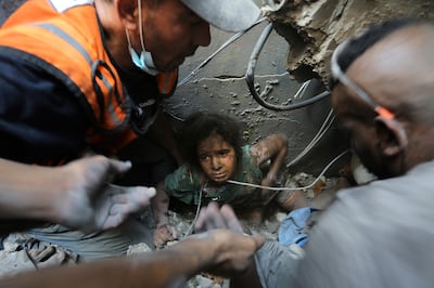 Palestinians try to pull a girl out of the rubble of a building destroyed by Israeli air strikes in Jabalia refugee camp, northern Gaza Strip. AP