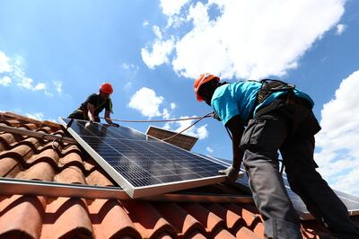 Rodrigue Kauahou and Jose Carlos Navarro, workers of the installation company Alromar, set up solar panels on the roof of a home in Colmenar Viejo, Spain June 19, 2020. Picture taken June 19, 2020. REUTERS/Sergio Perez