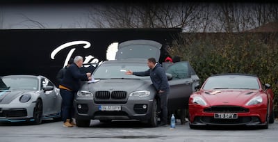 Romanian law enforcement officers complete the seizure papers for the luxury cars. EPA
