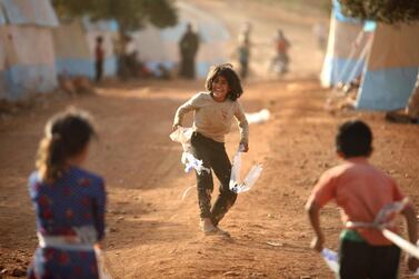 Displaced Syrian children play at a camp for internally displaced people near Kah, in the northern Idlib province near the border with Turkey on June 3, 2019 on the eve of Eid al-Fitr, which marks the end of the Muslim holy fasting month of Ramadan. The conflict in Syria has killed more than 370,000 people and displaced millions since it started in 2011. / AFP / Aaref WATAD