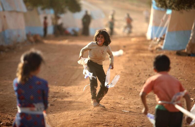 Displaced Syrian children play at a camp for internally displaced people near Kah, in the northern Idlib province near the border with Turkey on June 3, 2019 on the eve of Eid al-Fitr, which marks the end of the Muslim holy fasting month of Ramadan. The conflict in Syria has killed more than 370,000 people and displaced millions since it started in 2011. / AFP / Aaref WATAD
