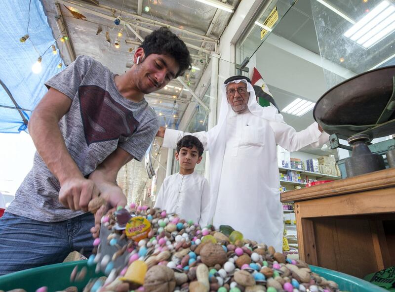 RAS AL KHAIMAH, UNITED ARAB EMIRATES, 26 APRIL 2018- Abdulla Ali Mohsin owner of Islamic Trading Est.,  one of the stores selling sweets and nuts for Hag Al Leila with his grandsons in Ras Al khaimah. Leslie Pableo for The National for Anna Zackarias story