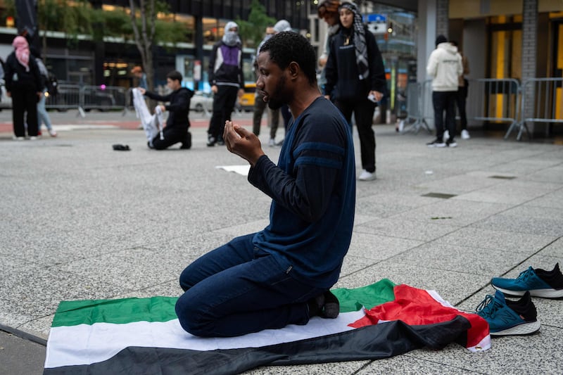 A man prays on the Palestinian flag near the Israeli Consulate in New York. Getty Images