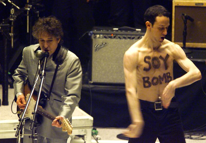 Bob Dylan performs his song Love Sick at the Grammys in 1998 as artist Michael Portnoy runs on stage with 'Soy Bomb' written on his chest