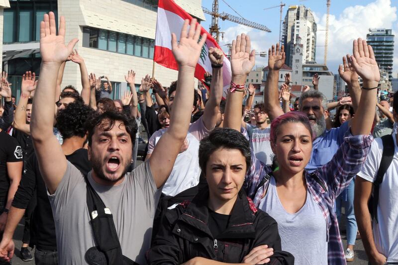 Anti-government protesters raise their hands after being attacked by Hezbollah supporters in Beirut, Lebanon, on Tuesday, Oct. 29, 2019. "I tried throughout this period to find a way out so we could listen to the people’s voices and protect the country," Lebanese Prime Minister Saad Hariri said hours after supporters of Iranian-backed Hezbollah attacked anti-government protesters in Beirut and destroyed their tents. Photographer: Hasan Shaaban/Bloomberg