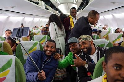 Passengers pose for a selfie picture inside an Ethiopian Airlines flight who departed from the Bole International Airport in Addis Ababa, Ethiopia, to Eritrea's capital Asmara on July 18, 2018.  The first commercial flight to Eritrea in two decades departed on July 18, 2018 from Addis Ababa after the two nations ended their bitter conflict in a whirlwind peace process.  / AFP / Maheder HAILESELASSIE TADESE
