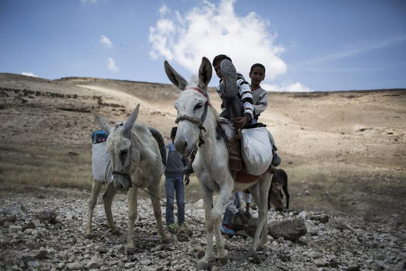 Pupils ride on a donkey after a day of lessons.