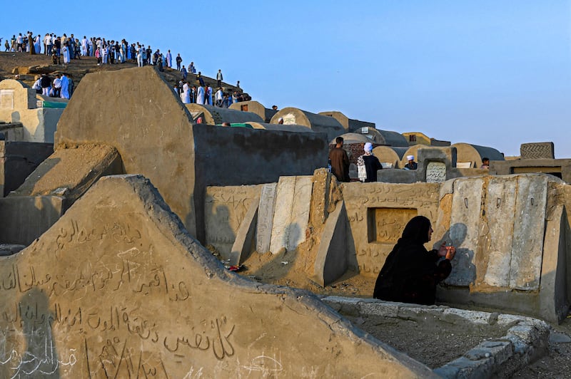 A Muslim woman prays at the grave of her relative in Abu Sir, Egypt. AFP