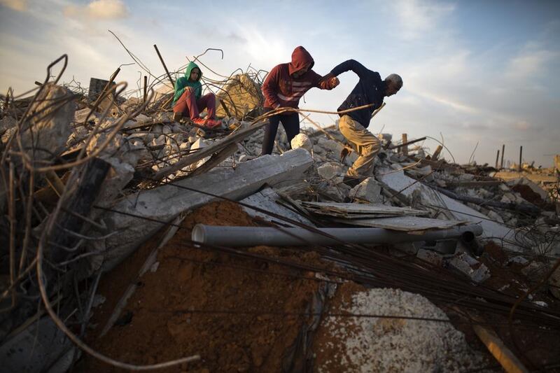 Hasounah Makhlouf with some of his family members in the rubble of one of their demolished homes in the Israeli Arab town of  Kalansuwa on January 10,2017. The razing of the 11 illegally built houses is one of the biggest demolition operations in the Arab sector in recent years. Heidi Levine for The National