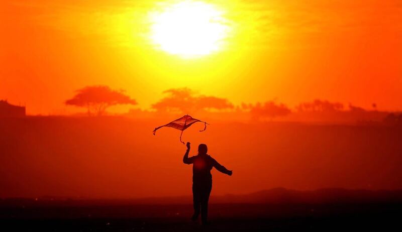 A girl flies a kite as the sun sets in Bnaider, some 33km south of Kuwait City. Yasser Al-Zayyat / AFP