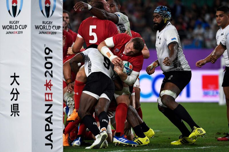 Wales' full back Liam Williams (C) is tackled by Fiji's scrum-half Frank Lomani (L)  during the Japan 2019 Rugby World Cup Pool D match between Wales and Fiji at the Oita Stadium in Oita. AFP