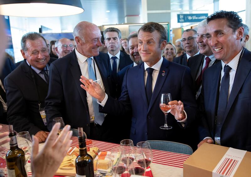 French President Emmanuel Macron,flanked by President of the Nouvelle-Aquitaine region Alain Rousset, samples local produce and wine, as he tours the exhibition hall above the international press center on the opening day of the G7 summit, in Anglet, France.  Reuters