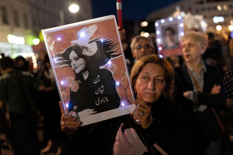A demonstrator holds a picture of Mahsa Amini during an evening march to commemorate the first anniversary of the death of Mahsa Amini in Berlin, Germany. Getty Images