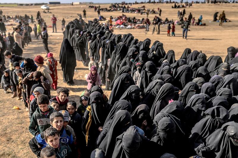 Civilians evacuated from the Islamic State (IS) group's embattled holdout of Baghouz wait for bread and water at a screening area held by the Kurdish-led Syrian Democratic Forces (SDF), in the eastern Syrian province of Deir Ezzor, on March 5, 2019. - More than 7,000 people, mostly women and children, have fled the shrinking pocket over the past two days, as US-backed forces press ahead with an offensive to crush holdout jihadists. (Photo by Bulent KILIC / AFP)