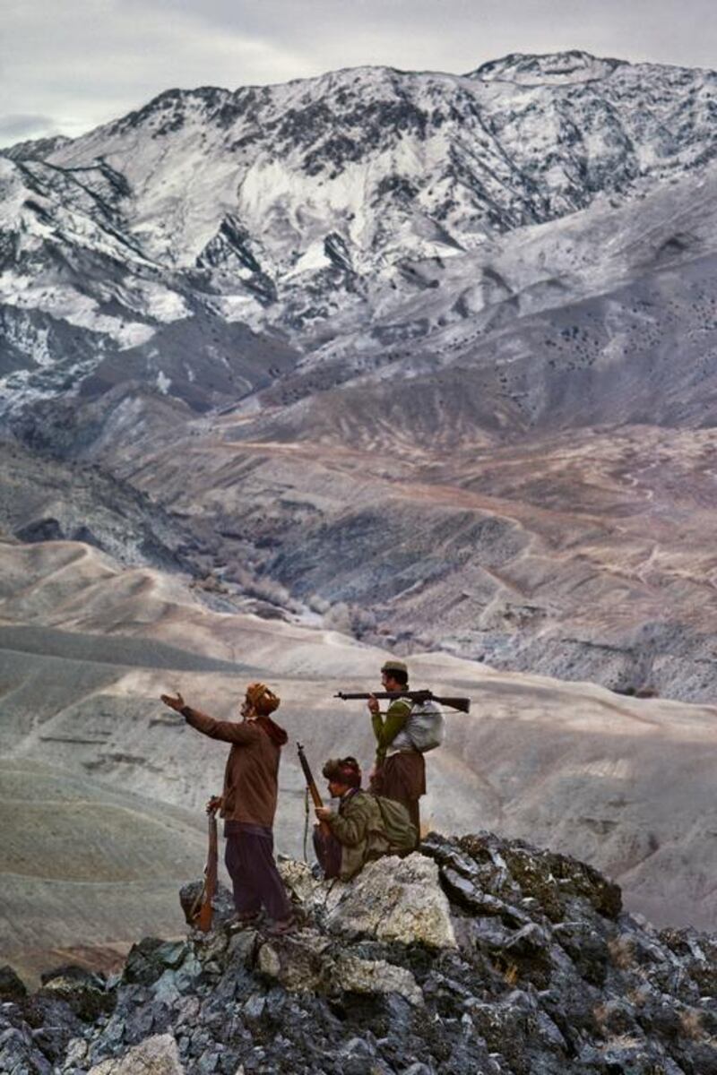 Men stand on top of the Hindu Kush Mountains in Afghanistan in 1984.