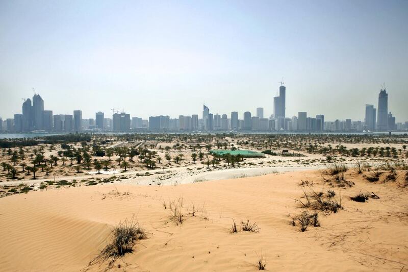 the Abu Dhabi skyline from the top of a man-made sand dune. Nicole Hill / The National