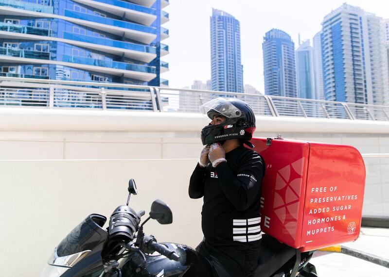DUBAI, UNITED ARAB EMIRATES. 14 MAY 2020. 
Rakesh Kumar, bike delivery rider at Freedom Pizza, puts on his safety helmet.
(Photo: Reem Mohammed/The National)

Reporter:
Section: