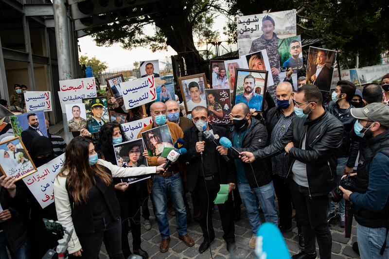 Ibrahim Hoteit, surrounded by the families of the victims of the Beirut blast, addresses the media outside the port of Beirut on the sixth-month anniversary of the explosion in February 2021.