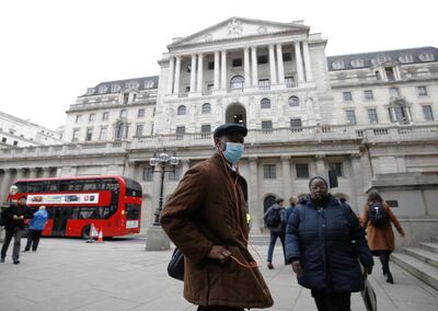 FILE PHOTO: A man, wearing a protective face mask, walks in front of the Bank of England, following an outbreak of the coronavirus, in London, Britain March 11, 2020. REUTERS/Henry Nicholls/File Photo