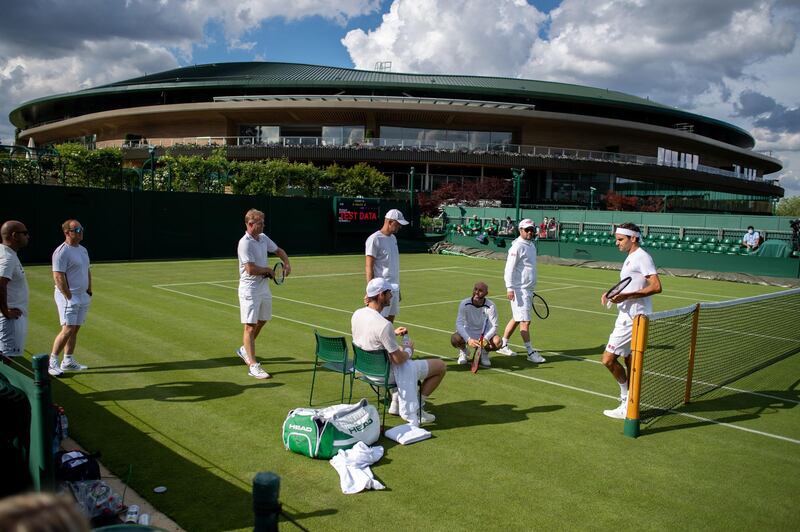 Roger Federer and Andy Murray practice on Court 14 at The All England Club on Friday. PA