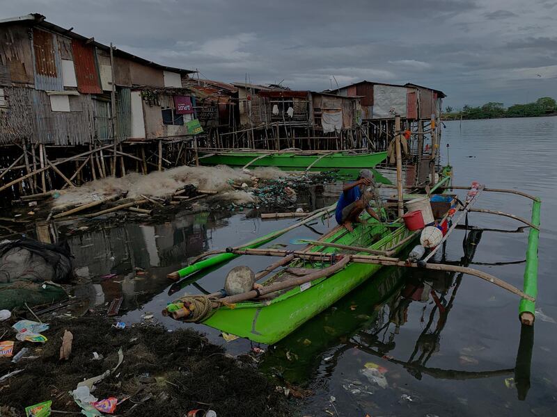 A fisherman folds a fishing net on Christmas day in Bacoor city, Philippines.  EPA