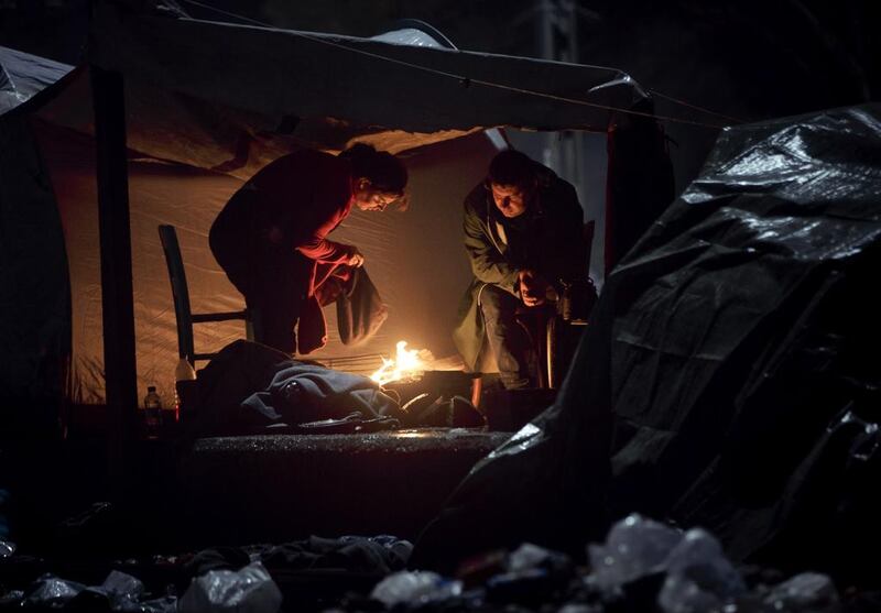 A woman dries clothing by a fire at the northern Greek border station of Idomeni. Vadim Ghirda / AP