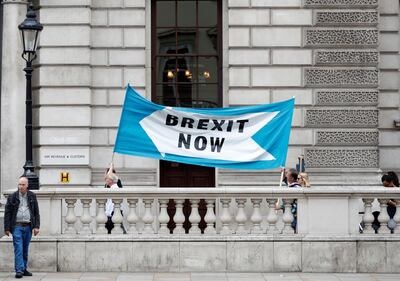 Pro Brexit demonstrators parade their banner past the Treasury building in London, Thursday, Aug. 29, 2019. Political opposition to Prime Minister Boris Johnson's move to suspend Parliament is crystalizing, with protests around Britain and a petition to block the move gaining more than 1 million signatures. (AP Photo/Alastair Grant)