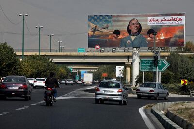 Vehicles drive on a highway under an anti-U.S. billboard with a portrait of former President Barack Obama, in Tehran, Iran, Tuesday, Nov. 3, 2020. The coronavirus pandemic forced authorities to cancel a planned commemoration of the Nov. 4, 1979 takeover of the U.S. Embassy in Tehran. The Persian writings on the billboard reads: "Whoever came inflicted evil. America remains the same." (AP Photo/Vahid Salemi)