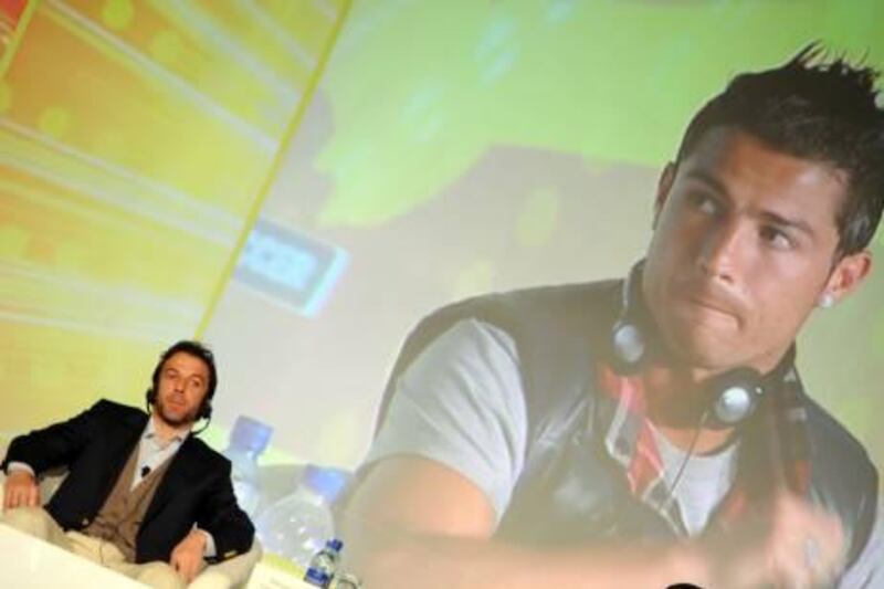 Italian legend Alessandro Del Piero sits under an image of Real Madrid's Cristiano Ronaldos as they attend on  December 28, 2011, the Sixth International Sports Council Conference in Dubai. Held under the patronage of Sheikh Hamdan bin Mohammed bin Rashid al-Maktoum, the Crown Prince of Dubai and Chairman of the Dubai Sports Council, the two-day event will discuss topics related to 'Football Companies...Current and Future Trends'. Ronaldo and will be the keynote speakers. AFP PHOTO/STR