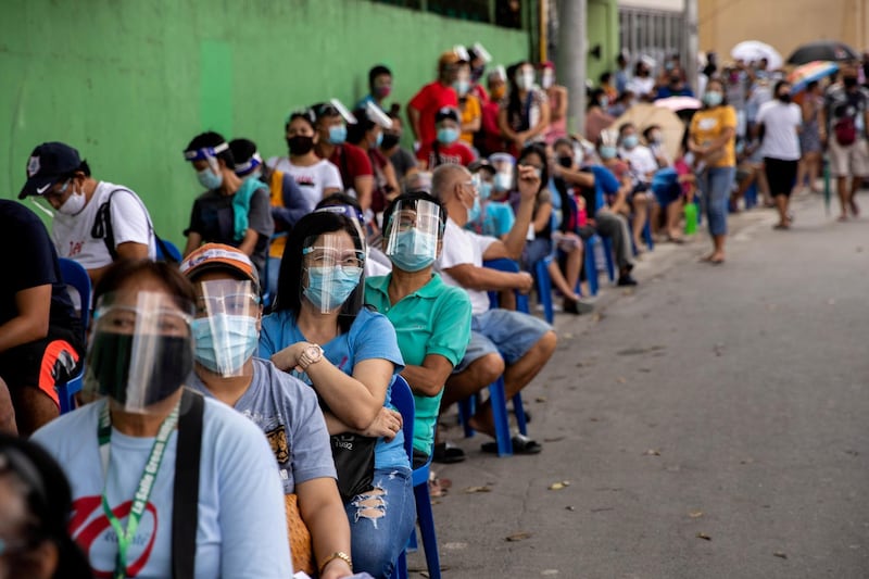 Filipinos queue Quezon City, Metro Manila for a government cash subsidy to offset the impact of the economic impact of the coronavirus pandemic. Reuters