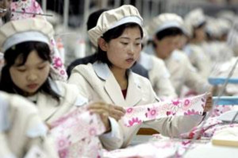 North Korean factory workers: the country's aggressive posturing is a carefully plotted business strategy.