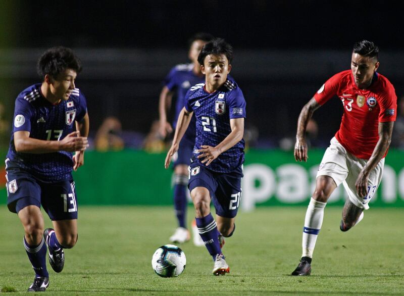Japan's Takefusa Kubo, centre, is chased by Chile's Erick Pulgar. AFP