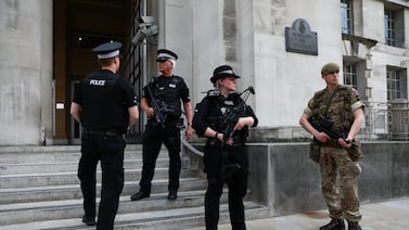 Armed police officers and a soldier stand outside the Ministry of Defence in London. Reuters