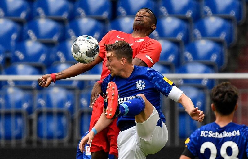 Schalke's Bastian Oczipka, and Augsburg's Felix Uduokhai, up, challenge for the ball. EPA