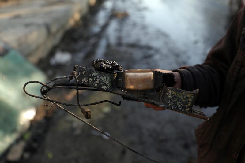 An Afghan boy holds the remains of a vehicle which was carrying and firing mortar shells in Kabul. The shells were fired from the northern edge of the capital and from a vehicle, Interior Ministry spokesman Tariq Arian said.AP Photo