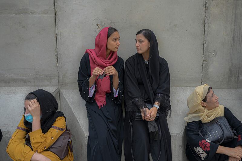 Afghan women wait in front of a bank in Kabul a month after the Taliban takeover. AFP