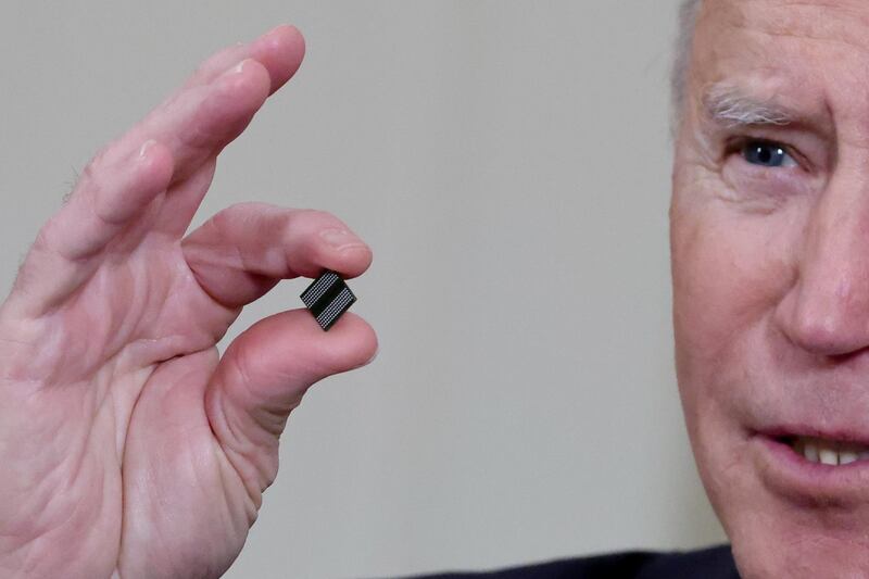 US President Joe Biden holds a semiconductor chip before signing an executive order aimed at addressing a shortage of the chips. Reuters