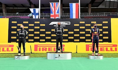 SPIELBERG, AUSTRIA - JULY 12: Race winner Lewis Hamilton of Great Britain and Mercedes GP (C), second placed Valtteri Bottas of Finland and Mercedes GP (L) and third placed Max Verstappen of Netherlands and Red Bull Racing (R) stand on the podium after the Formula One Grand Prix of Styria at Red Bull Ring on July 12, 2020 in Spielberg, Austria. (Photo by Joe Klamar/Pool via Getty Images)