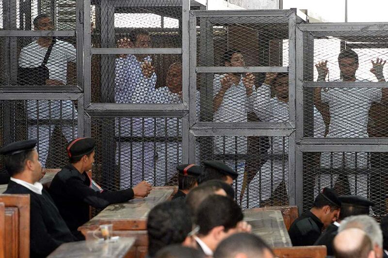 Journalists stand in court's cage during their trial for allegedly supporting a terrorist group and spreading false information, in Cairo, Egypt. Tarek Wajeh / EPA